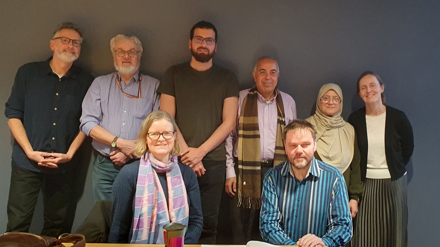 Rachid standing with seven members of the project team in a meeting room